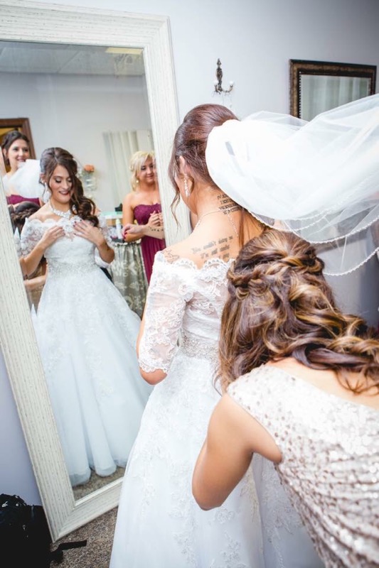 bride looking at herself wearing her wedding dress in the mirror